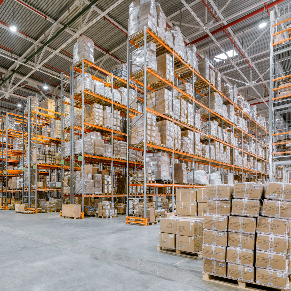Large warehouse. Tall metal shelves filled with various boxes, containers and drawers.