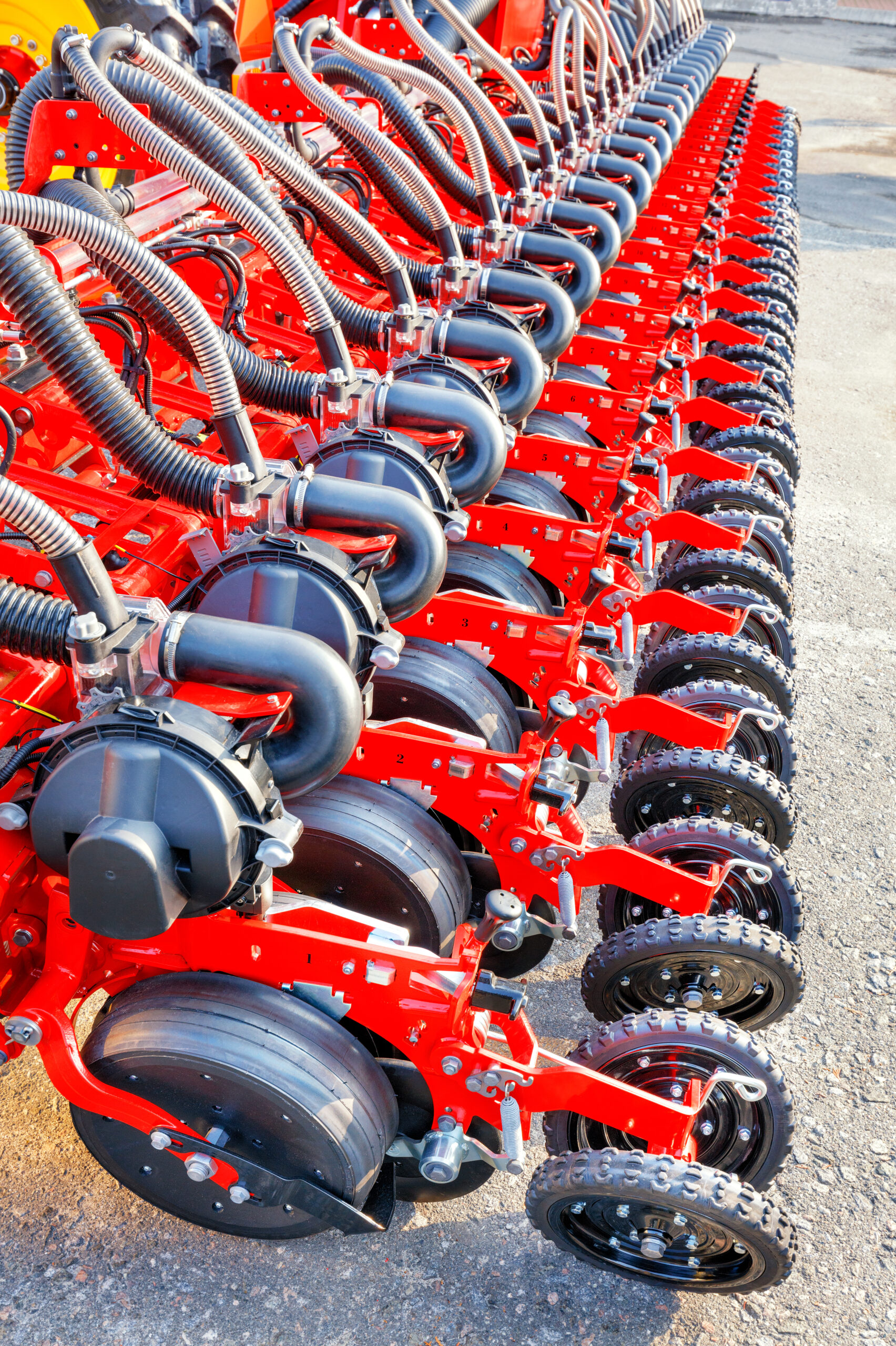 The mechanism of a modern seeder used in the agricultural sector. Red modern seeder, working mechanisms of a multi-row modern pneumatic agricultural seeder.